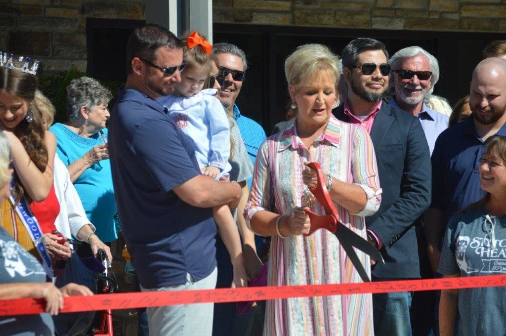 A crowd of 200 gathered for the ribbon-cutting of Stitchin’ Heaven sponsored by the Quitman Chamber of Commerce Monday. Pictured are owner Debbie Luttrell cutting the ribbon with her son Clay and granddaughter Aspen. The 17,500-square-foot facility is located in the Quitman business park.